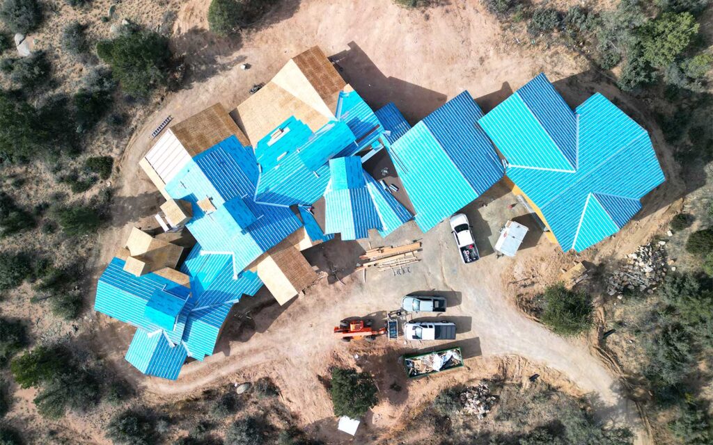 Aerial view of a Prescott custom home under construction in American Ranch with roofing being installed
