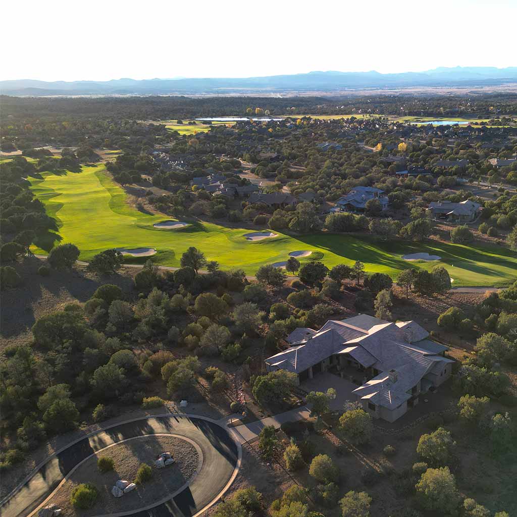 Aerial view of a Prescott custom home in Talking Rock Ranch backing to the golf course at sunset