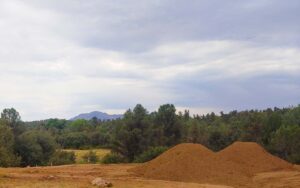 Lot prep dirt work on a Talking Rock Ranch custom home site with Granite Mountain in the background