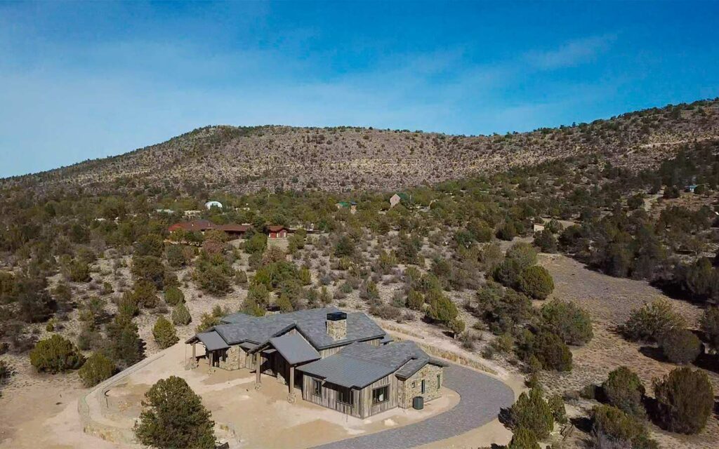 Aerial view of an HBC Sterling Ranch custom home with natural high-desert landscape and surrounding hills