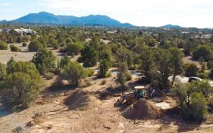 Talking Rock Ranch Custom Home Lot Grading – Granite Mountain Aerial - Hughes Building Company | Luxury Custom Homes | Prescott, AZ Drone view of a new Talking Rock Ranch custom home lot being graded with Granite Mountain in the background