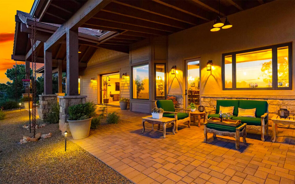 Prescott custom home outdoor living patio with covered seating and sunset lighting