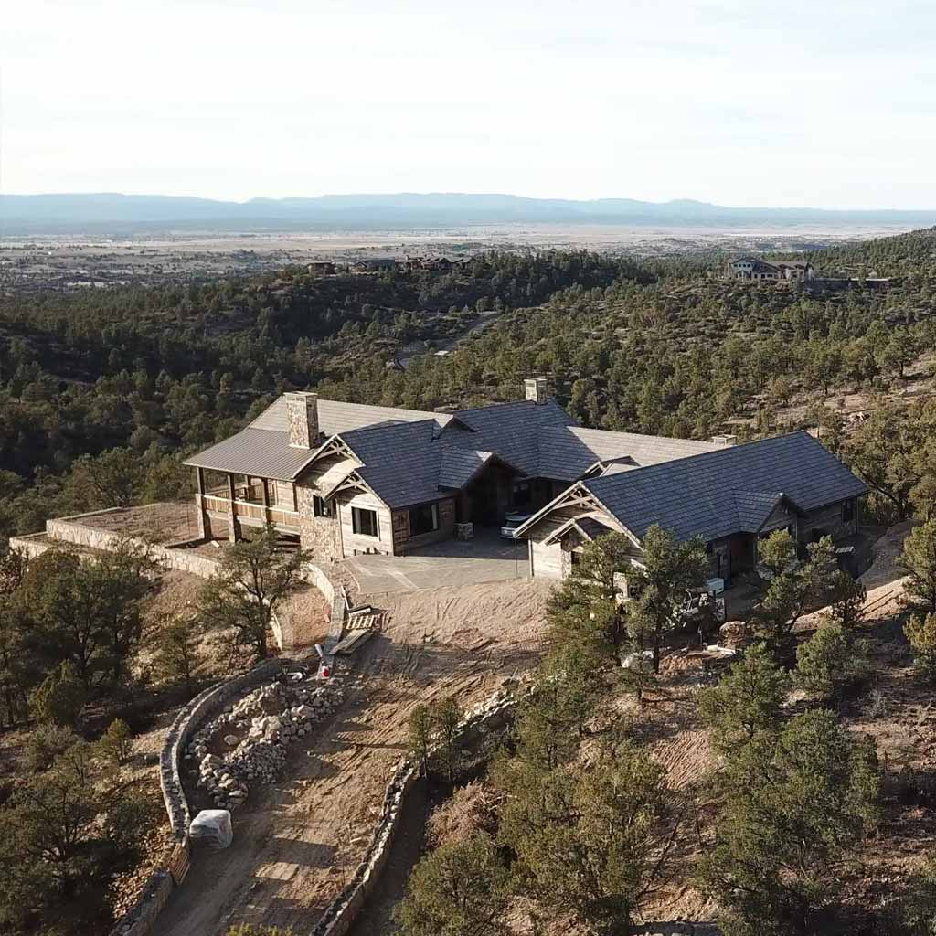 Stone-and-timber front entry on a Preserve at the Ranch custom home with covered porch and paver approach in Williamson Valley near Prescott, AZ.