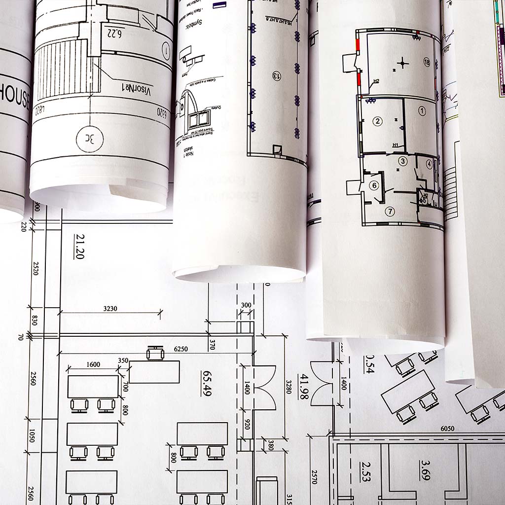 Rolled architectural floor plans representing the mistake of starting a Prescott custom home project with a plan before evaluating the lot