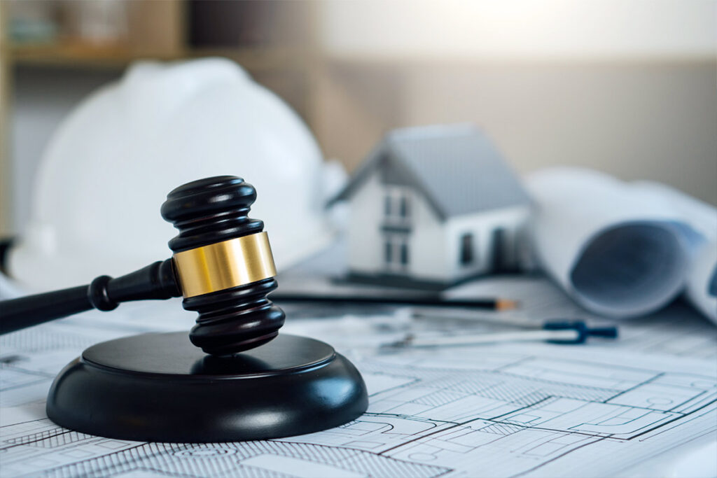 Construction plans, hard hats, house model, and gavel representing the Talking Rock Ranch design review board process for custom homes