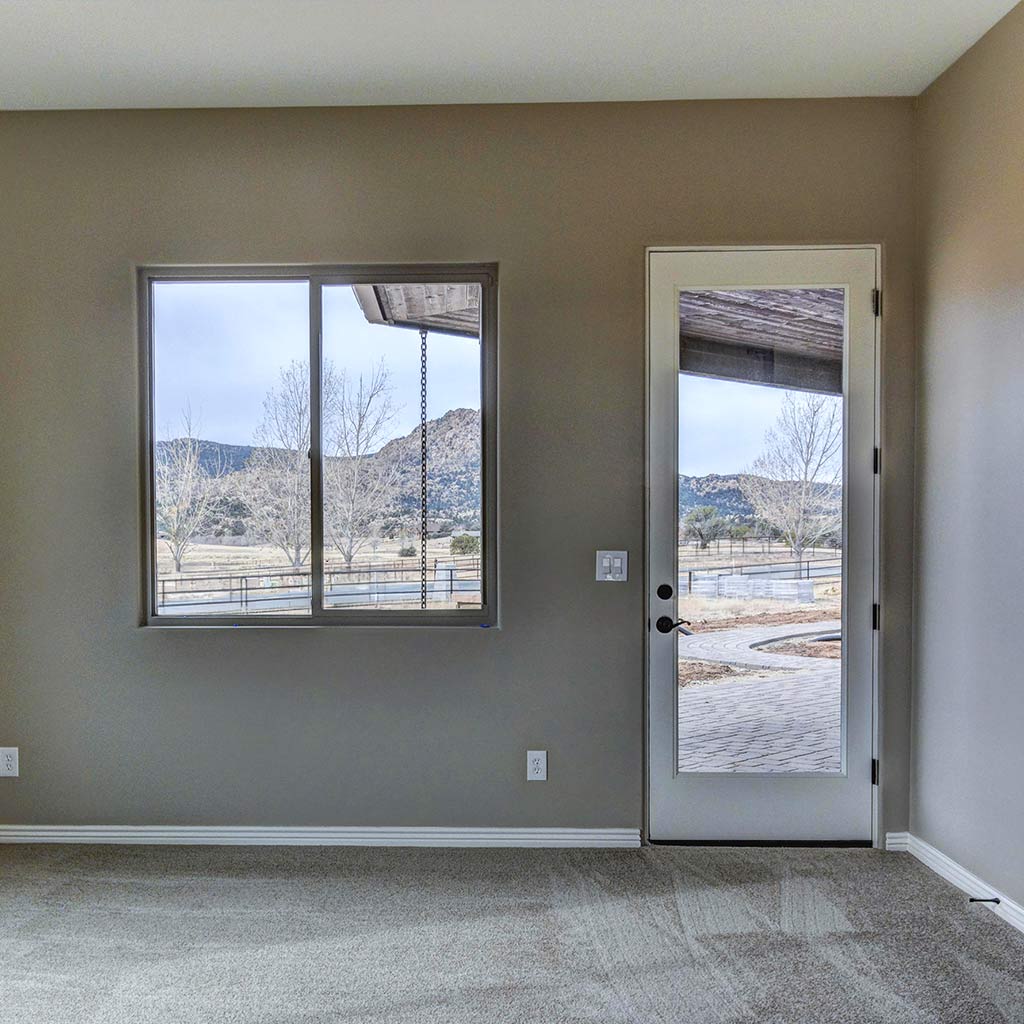 Interior room in an HBC custom home in American Ranch with windows and door framing views of Granite Mountain and the surrounding Prescott landscape