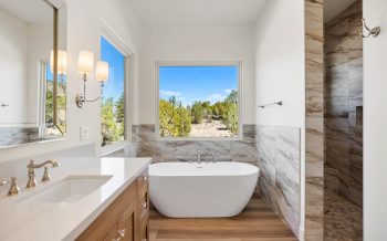 Sterling Ranch custom home primary bath with soaking tub, walk-in shower, and picture window views