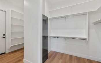 Sterling Ranch custom home primary closet with built-in shelving and hanging storage